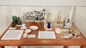 exhibit case containing bottles, shells, etc